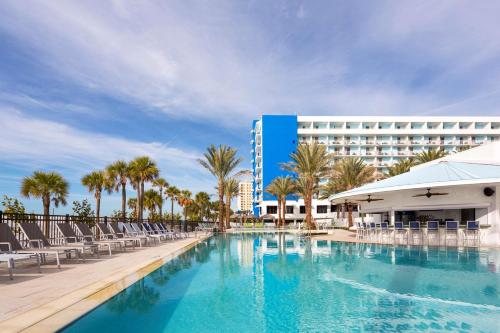 una piscina con sedie e un hotel di Hilton Clearwater Beach Resort & Spa a Clearwater Beach