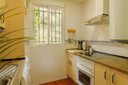 una pequeña cocina con fregadero y ventana en Casa Rural La Goleta, en San Martín de Valdeiglesias
