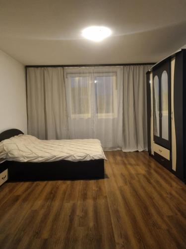 um quarto com uma cama e piso em madeira em Apartament central em Piteşti
