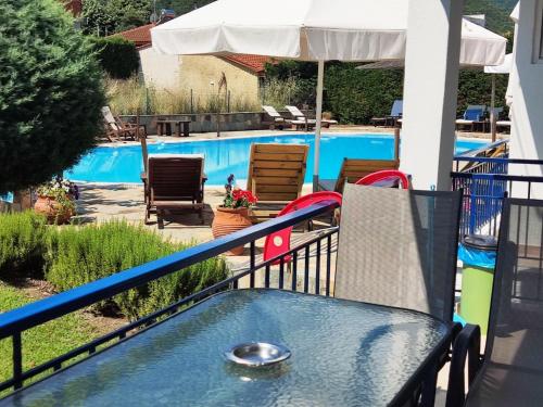 a balcony with a table and a swimming pool at Villa Riviera in Stavros