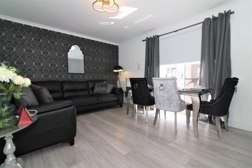 2 Bedroom Apartment at SECC Hydro FREE PARKING في غلاسكو: غرفة معيشة مع أريكة وطاولة وكراسي