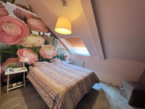 ein Schlafzimmer mit einem Bett mit Blumen an der Wand in der Unterkunft Ancienne poste Malmedy in Malmedy