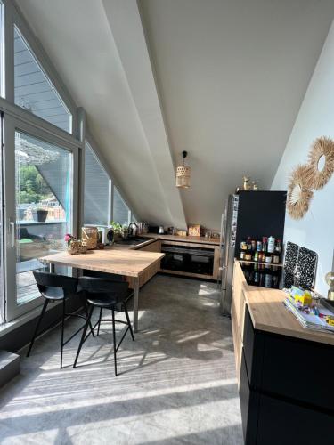 a large kitchen with a table and a refrigerator at Ancienne poste Malmedy in Malmedy