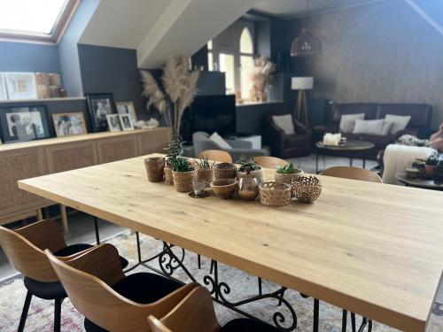 een houten tafel met potplanten in een kamer bij Ancienne poste Malmedy in Malmedy