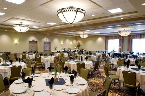 a banquet hall with white tables and chairs and chandeliers at Hilton Garden Inn Pensacola Airport/Medical Center in Pensacola