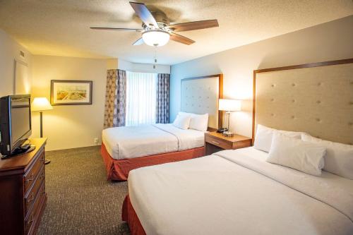 a hotel room with two beds and a flat screen tv at Homewood Suites by Hilton Pensacola Airport-Cordova Mall Area in Pensacola