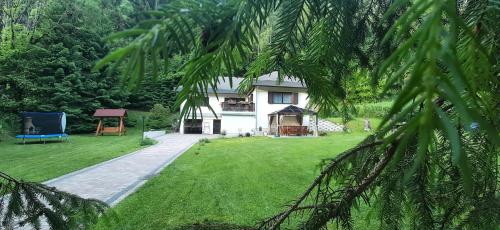 Am Kaltenbach - Spital am Semmering, Stuhleck في سبيتال آم سيميرينغ: منزل مع ساحة خضراء مع منزل