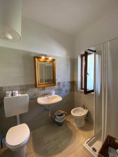 a bathroom with a toilet and a sink and a mirror at Bed & Breakfast Alex in Porto Azzurro