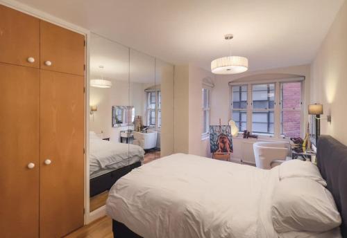 a bedroom with two beds and a mirror at Covent Garden Haven - 2 Bedrooms. 2 Bathrooms in London