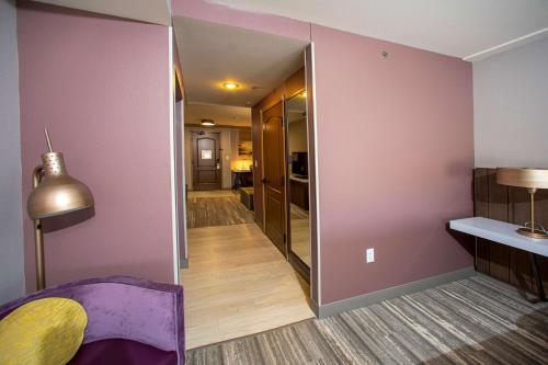 a living room with a mirror and a purple chair at Hilton Garden Inn Rapid City in Rapid City