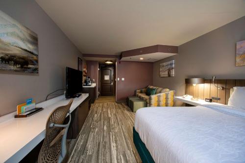 a hotel room with a bed and a couch at Hilton Garden Inn Rapid City in Rapid City