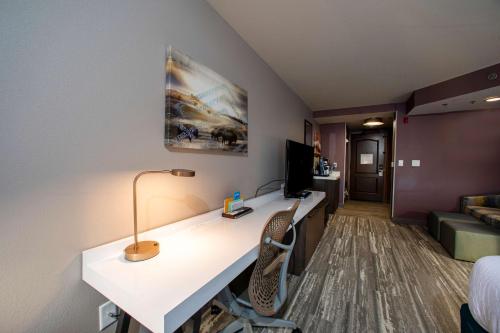 a room with a desk with a computer and a couch at Hilton Garden Inn Rapid City in Rapid City