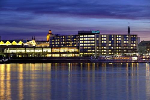 un gran edificio iluminado por la noche en Hilton Mainz, en Mainz