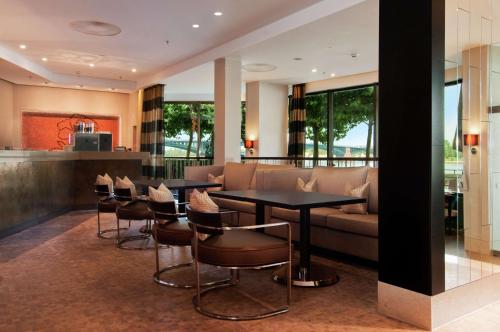 a living room with a couch and a table and chairs at Hilton Mainz in Mainz