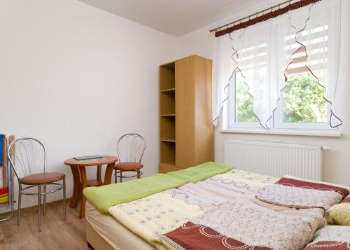 1 dormitorio con 1 cama, mesa y sillas en Pokoje Gościnne MAJK, en Ustronie Morskie