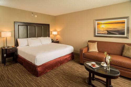 una camera d'albergo con letto e divano di DoubleTree by Hilton Raleigh Durham Airport at Research Triangle Park a Durham