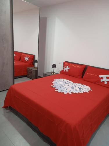 a bedroom with a red bed and a red couch at CARPE DIEM in Oristano