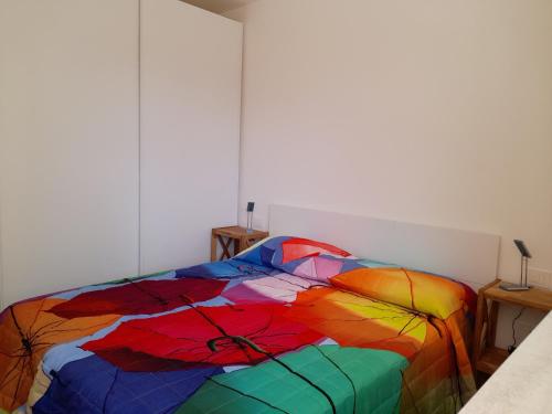 a bedroom with a rainbow colored comforter on a bed at CARPE DIEM in Oristano