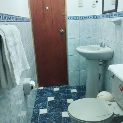 y baño con aseo y lavamanos. en Departamento amoblado Santa Beatriz, en Tacna
