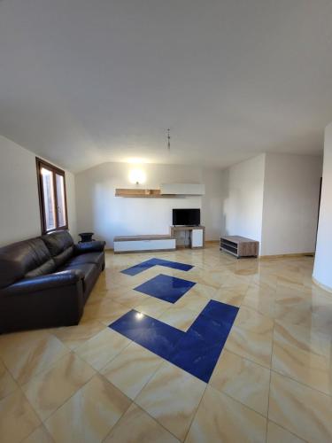 - un salon avec un canapé noir et un tapis bleu dans l'établissement DA DANY e ELIA, à Irgoli