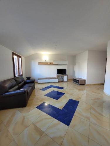 a living room with a black couch and a blue rug at DA DANY e ELIA in Irgoli