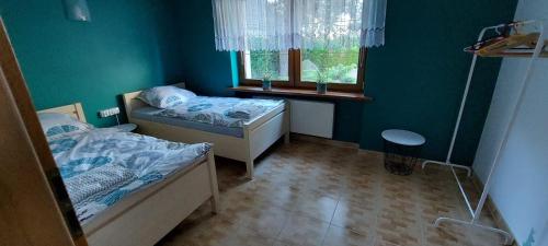 um pequeno quarto com 2 camas e uma janela em U Magdy em Gniezno