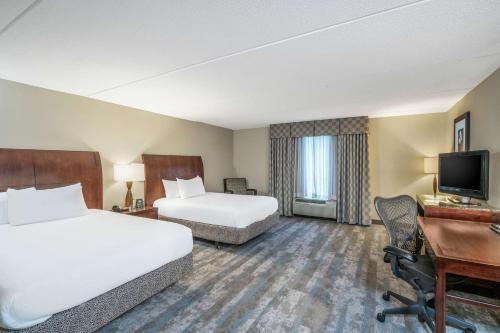 a hotel room with two beds and a desk at Hilton Garden Inn Richmond Airport in Sandston