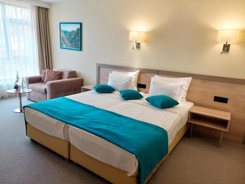 Habitación de hotel con cama grande con almohadas azules en Hotel Siesta en Užice