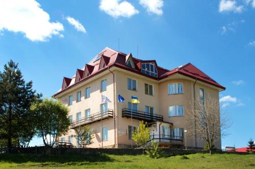 a large building with a red roof at Kamyanka in Mizhhirʼʼya
