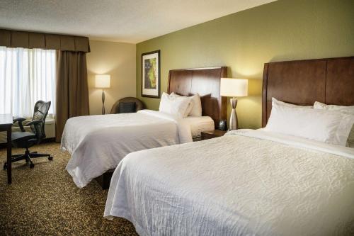 a hotel room with two beds and a desk at Hilton Garden Inn Richmond Innsbrook in Short Pump