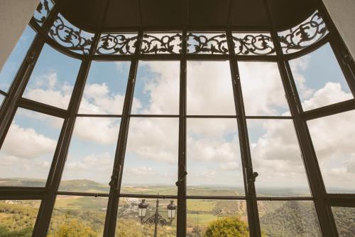 a glass window with a view of the mountains at Casa Aura Hotel in Vejer de la Frontera