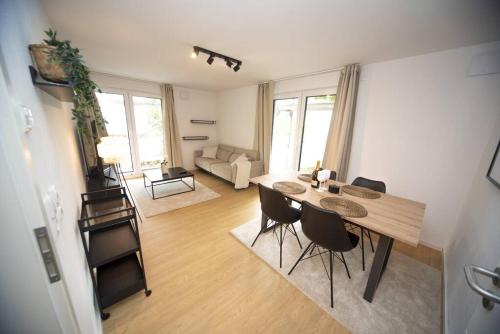 uma sala de estar com uma mesa de madeira e cadeiras em Central Apartment / BBQ Terrace / Big NetflixTV em Bayreuth