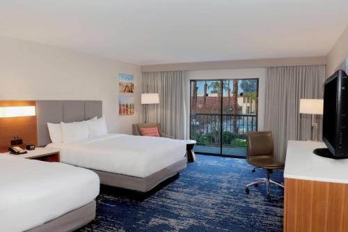 een hotelkamer met 2 bedden en een televisie bij DoubleTree by Hilton Bakersfield in Bakersfield