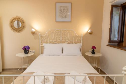 una camera con un letto bianco con due tavoli di Bardis Hidden Gem a Volos