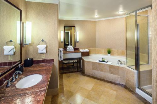 a bathroom with a tub and a sink and a shower at DoubleTree by Hilton Sonoma Wine Country in Rohnert Park