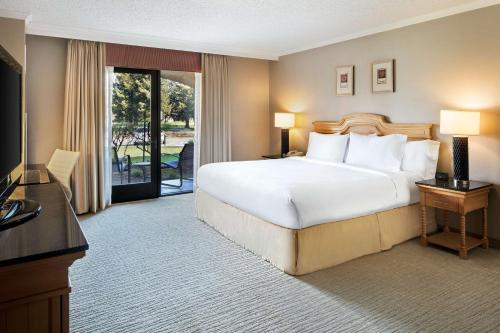 a hotel room with a large bed and a balcony at DoubleTree by Hilton Sonoma Wine Country in Rohnert Park