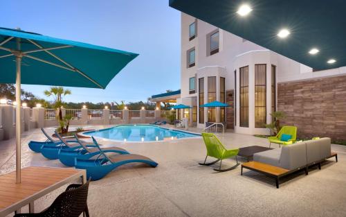 a patio with chairs and a pool and a building at Hampton Inn & Suites Rockport-Fulton in Rockport