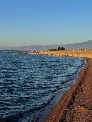 a body of water with a beach and mountains in the background at Tunuk Guest House in Tossor