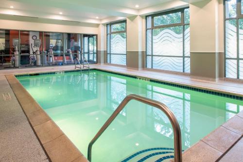 a swimming pool in a building with windows at Embassy Suites by Hilton Sacramento Riverfront Promenade in Sacramento