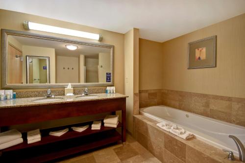 a bathroom with a tub and a large mirror at Hampton Inn Rutland/Killington in Rutland