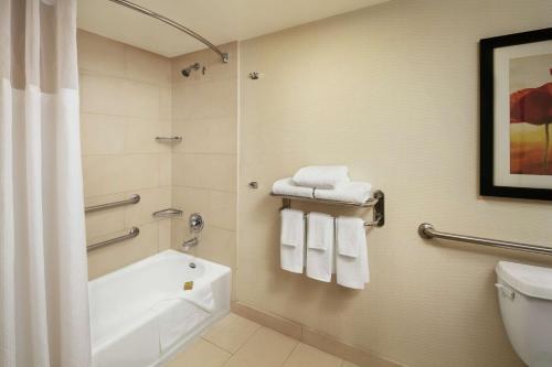 a bathroom with a tub and a toilet and towels at DoubleTree By Hilton San Diego Hotel Circle in San Diego