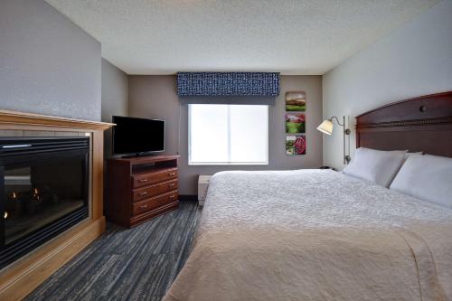 a hotel room with a bed and a fireplace at Hampton Inn Rutland/Killington in Rutland