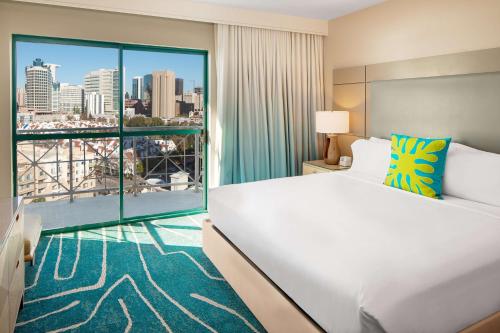 a hotel room with a bed and a large window at Embassy Suites by Hilton San Diego Bay Downtown in San Diego