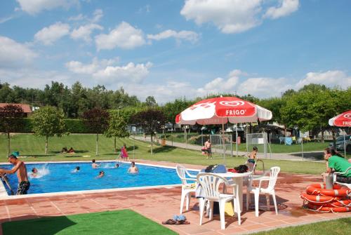 una piscina en un parque con gente nadando en ella en Camping Lluçanès en Olost