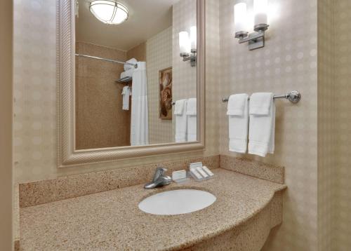 a bathroom with a sink and a mirror and towels at Hilton Garden Inn San Diego Del Mar in San Diego