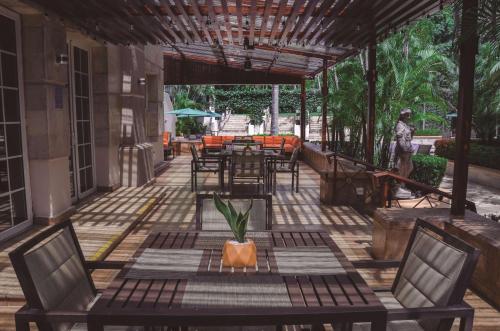 an outdoor patio with tables and chairs and a person at Hilton Princess San Pedro Sula in San Pedro Sula