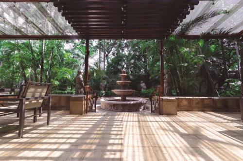 a patio with a fountain in the middle of a forest at Hilton Princess San Pedro Sula in San Pedro Sula