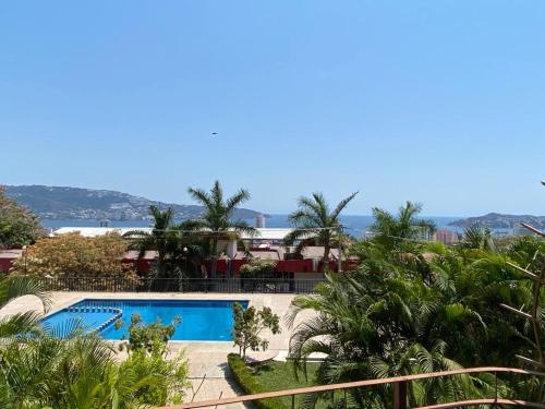 un complejo con piscina y palmeras en CONDOMINIO PALMEIRAS en Acapulco