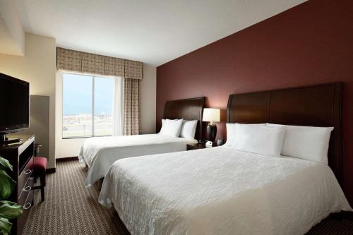 a hotel room with two beds and a window at Hilton Garden Inn New Braunfels in New Braunfels