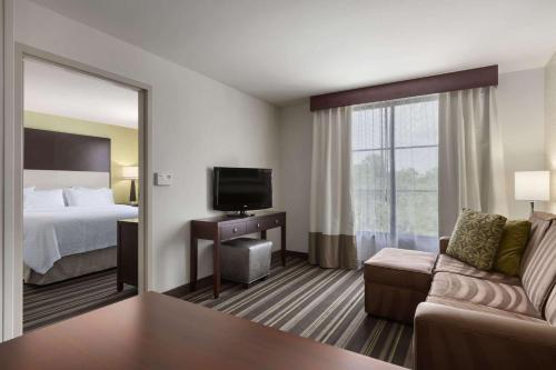 a hotel room with a bed and a television at Embassy Suites Savannah Airport in Savannah